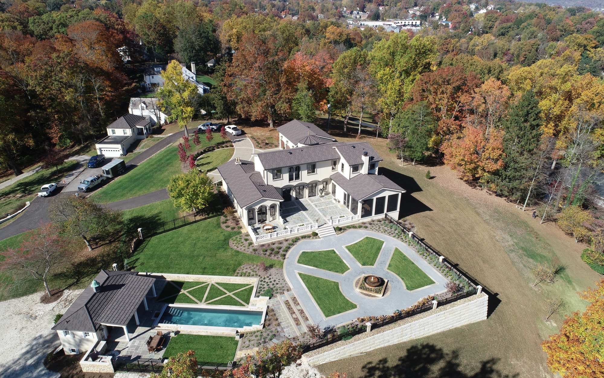 Aerial view of a private estate landscaped by Valley Gardens, with a formal parterre garden, central fountain, terraced lawns and pool house