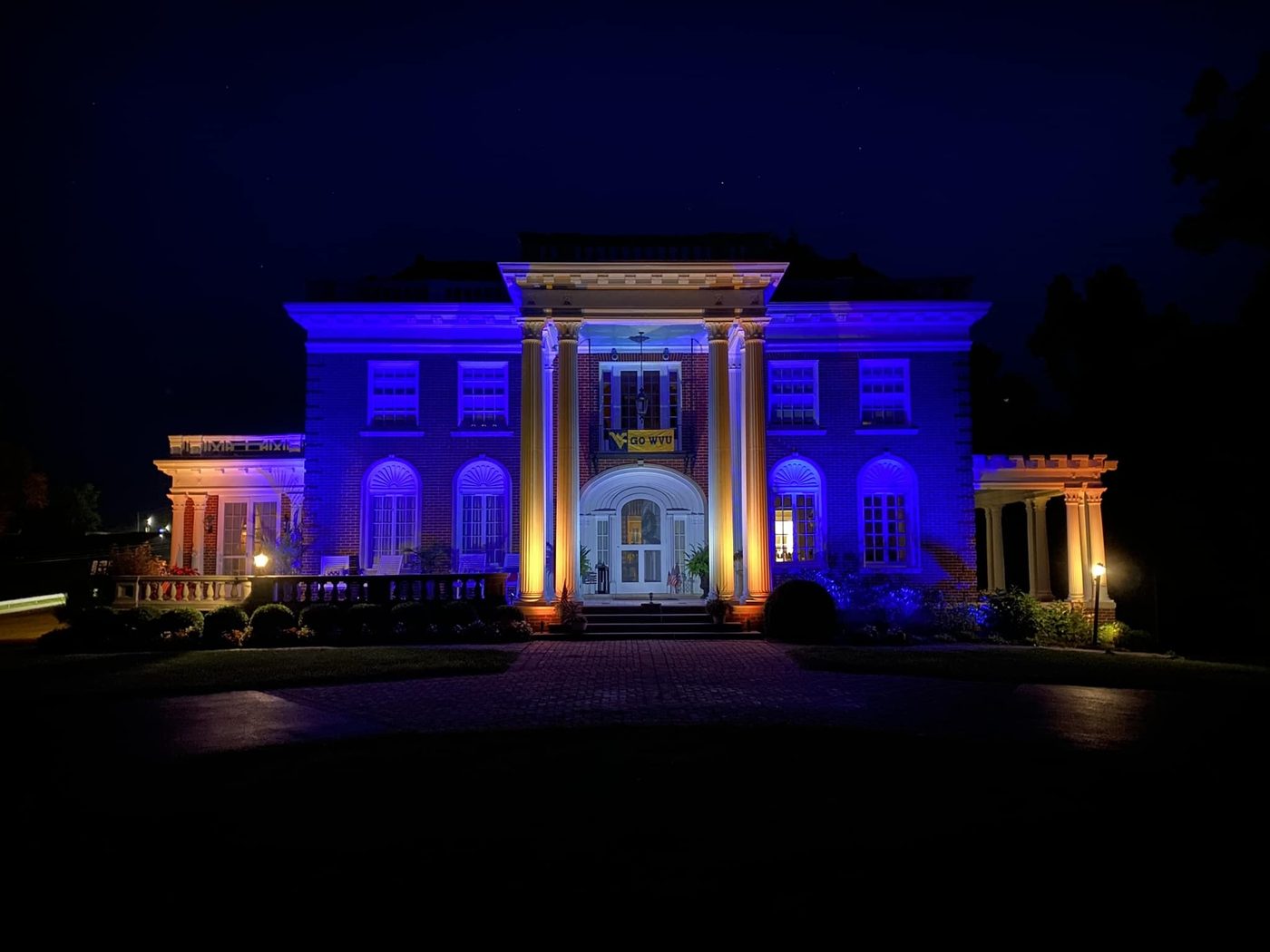 Colored architectural uplighting across a columned brick facade